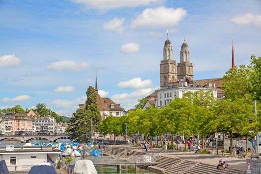 Zurich, Switzerland - June 10, 2017: Minster Grossmunster, view from Quaibrucke bridge, river Limmat in front.