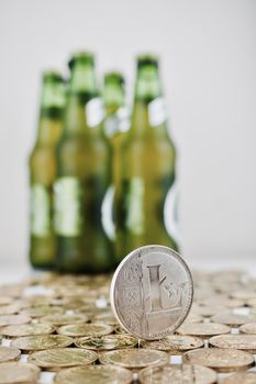 Digital currency physical silver litecoin coin on the money nerar green beer bottles.