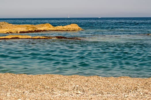 Sand the rocks and a blue Mediterranean sea