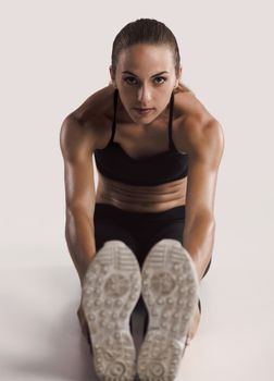 Shot of a young woman doing stretching exercises 