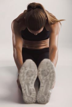 Shot of a young woman doing stretching exercises 