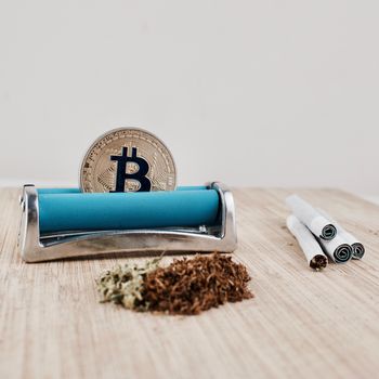Digital currency physical gold bitcoin coin. Addict marijuana and joints concept.