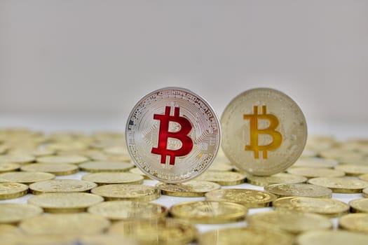 Digital currency physical red bitcoin coin near yellow bitcoin. Business concept.