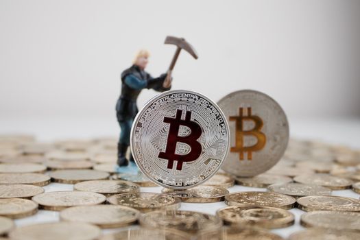 Digital currency physical silver bitcoin coin with red and yellow sign.