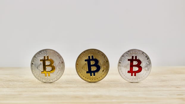 Bitcoins. Physical cryptocurrency gold and silver coins on the wooden board.