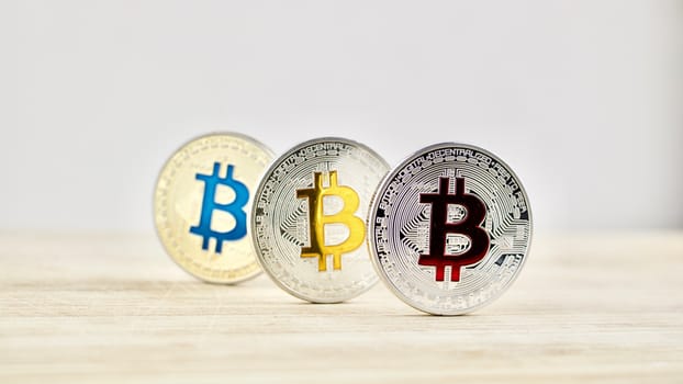 Digital currency physical silver and gold bitcoin coins on the wooden board.