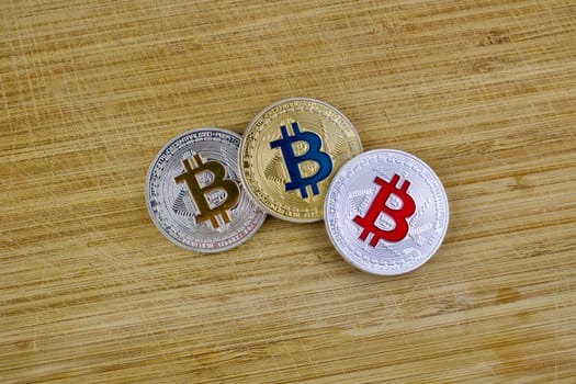 Digital currency physical silver and gold bitcoin coins on the wooden board.