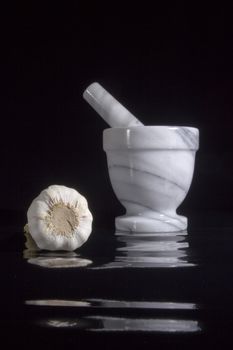 Garlic in mortar and pestle on a black background
