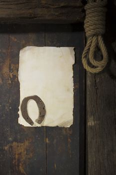 Rusty horseshoe and rope on an old wooden door