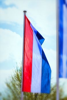 National flag of the Netherlands, Holland in high format with motion blur in the background.