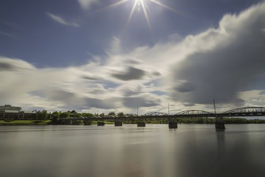 Bride over River in Umea, Sweden with a partly cloudy sky.