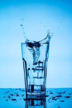 Splashing water from a glass with ice cubes