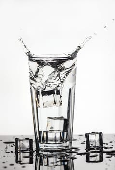 Splashing water from a glass with ice cubes