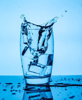 Splashing water from a glass with ice cubes