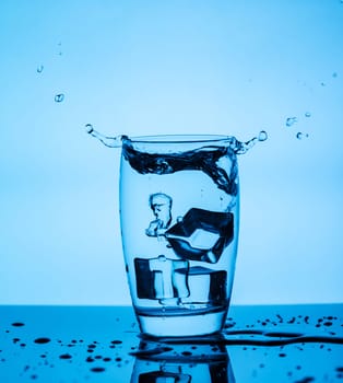 Splashing water from a glass with ice cubes