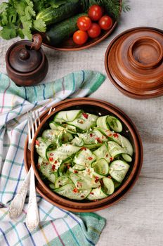 A bowl of salad from cucumber strips with spices, garlic and dill. Rustic style.