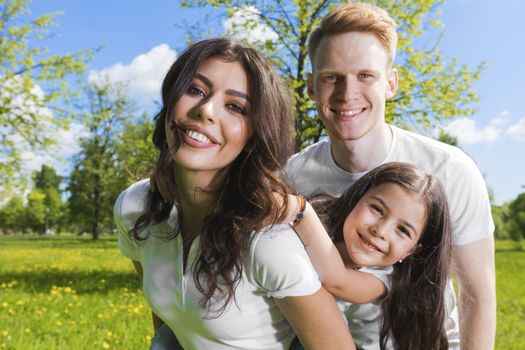 Portrait of cheerful family in summer sunny park
