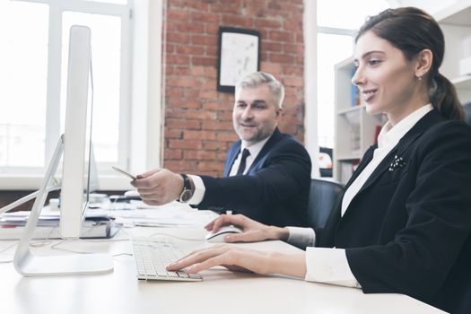 Business people working in the office, pointing to computer monitor