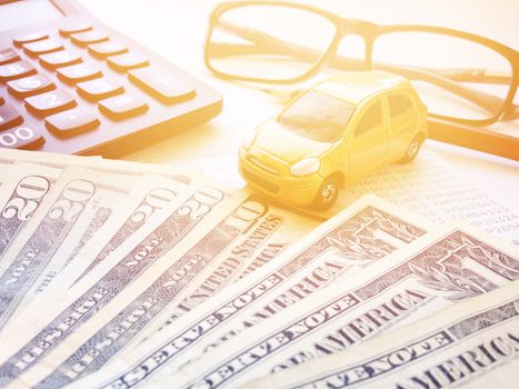 Business, finance, savings, banking or car loan concept : Miniature car model, pencil, calculator, eyeglasses, money and savings account passbook or financial statement on white background