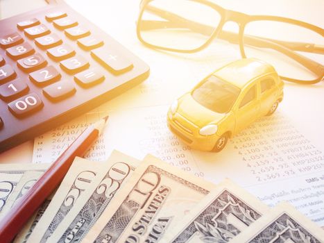Business, finance, savings, banking or car loan concept : Miniature car model, pencil, money, calculator, eyeglasses and savings account passbook or financial statement on white background