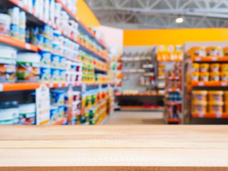 Light wooden empty table in front of blurred DIY supermarket background. Mock up for display of product.