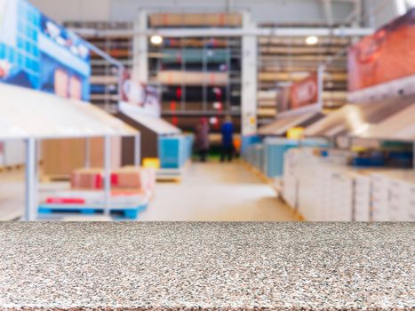 Marble empty table in front of blurred DIY supermarket background. Mock up for display of product.