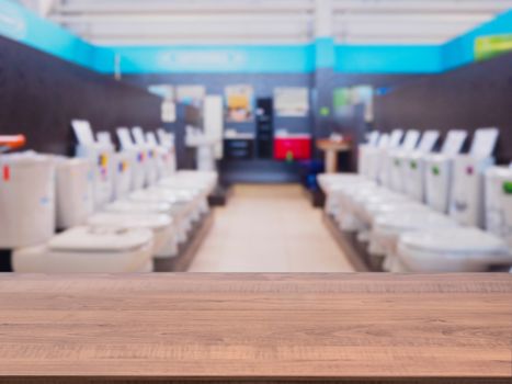 Brown wooden empty table in front of blurred DIY supermarket background. Mock up for display of product.