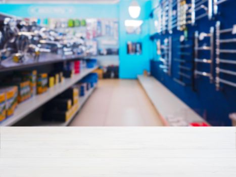 White wooden empty table in front of blurred DIY supermarket background. Mock up for display of product.