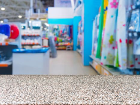 Marble empty table in front of blurred DIY supermarket background. Mock up for display of product.