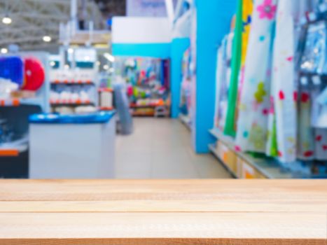 Light wooden empty table in front of blurred DIY supermarket background. Mock up for display of product.