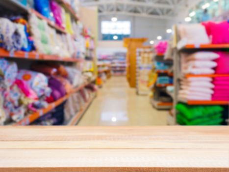 Light wooden empty table in front of blurred DIY supermarket background. Mock up for display of product.