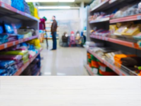 White wooden empty table in front of blurred DIY supermarket background. Mock up for display of product.