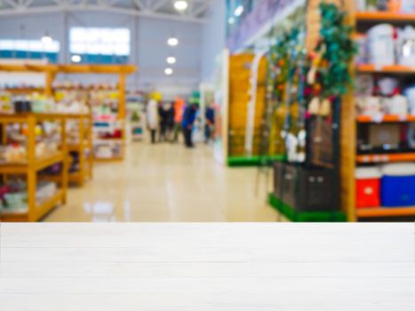 White wooden empty table in front of blurred DIY supermarket background. Mock up for display of product.