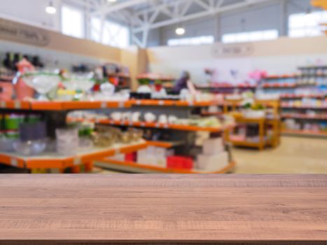 Brown wooden empty table in front of blurred DIY supermarket background. Mock up for display of product.