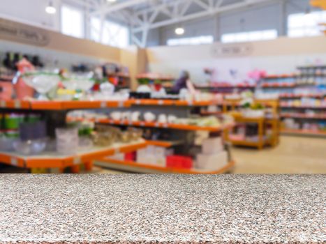 Marble empty table in front of blurred DIY supermarket background. Mock up for display of product.