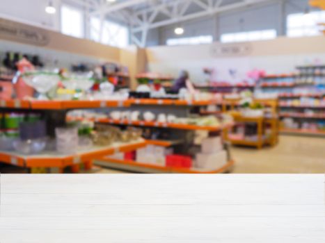 White wooden empty table in front of blurred DIY supermarket background. Mock up for display of product.