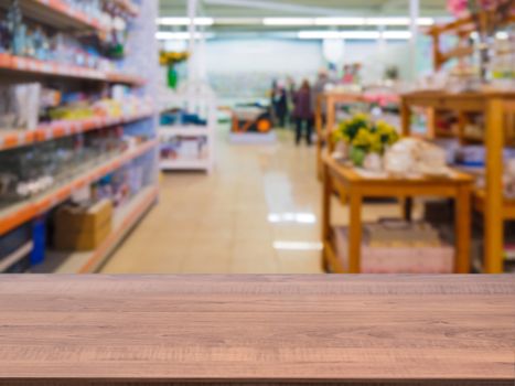 Brown wooden empty table in front of blurred DIY supermarket background. Mock up for display of product.