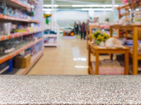 Marble empty table in front of blurred DIY supermarket background. Mock up for display of product.