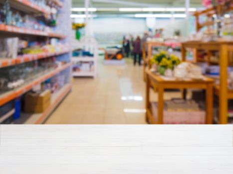 White wooden empty table in front of blurred DIY supermarket background. Mock up for display of product.