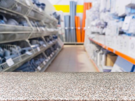 Marble empty table in front of blurred DIY supermarket background. Mock up for display of product.