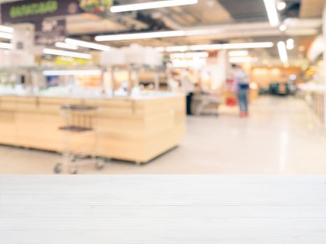 White wooden board empty table in front of blurred background. Perspective white wood over blur in supermarket - can be used for display or montage your products. Mockup for display of product.