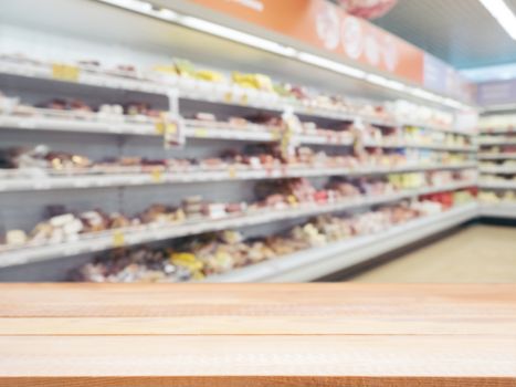 Light wooden board empty table in front of blurred background. Perspective light wood over blur in supermarket - can be used for display or montage your products. Mockup for display of product.