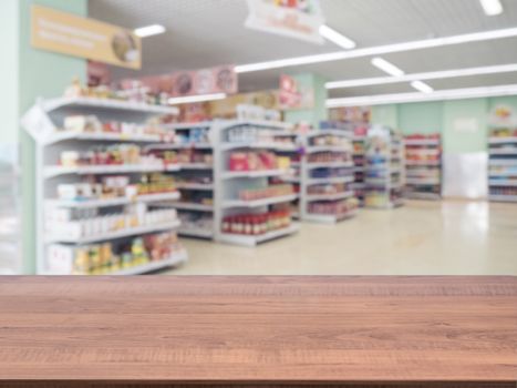 Brown wooden board empty table in front of blurred background. Perspective dark wood over blur in supermarket - can be used for display or montage your products. Mockup for display of product.