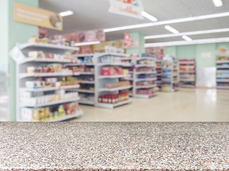 Marble board empty table in front of blurred supermarket - can be used for display or montage your products. Mockup for display of product.