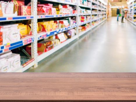 Brown wooden board empty table in front of blurred background. Perspective dark wood over blur in supermarket - can be used for display or montage your products. Mockup for display of product.