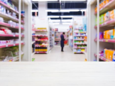 White wooden board empty table in front of blurred background. Perspective white wood over blur in supermarket - can be used for display or montage your products. Mockup for display of product.