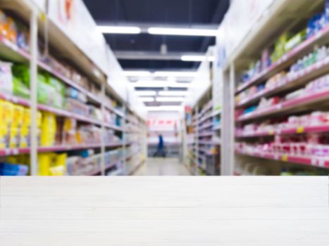 White wooden board empty table in front of blurred background. Perspective white wood over blur in supermarket - can be used for display or montage your products. Mockup for display of product.