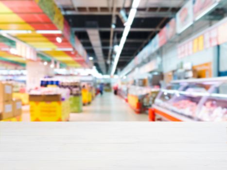 White wooden board empty table in front of blurred background. Perspective white wood over blur in supermarket - can be used for display or montage your products. Mockup for display of product.