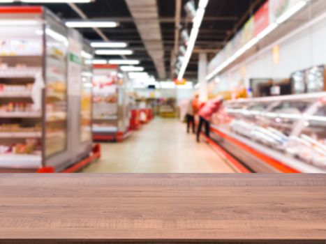 Brown wooden board empty table in front of blurred background. Perspective dark wood over blur in supermarket - can be used for display or montage your products. Mockup for display of product.