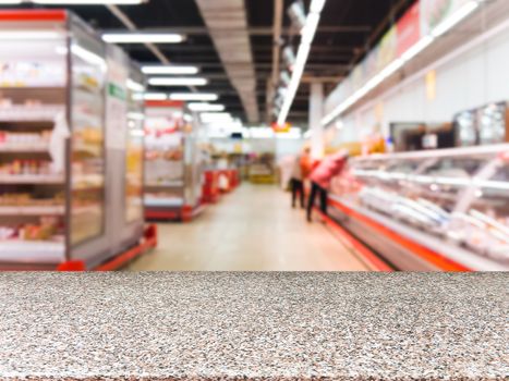 Marble board empty table in front of blurred supermarket - can be used for display or montage your products. Mockup for display of product.